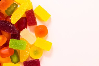 Fotokopi alanı olan pembe arkaplandaki çeşitli jöle şekerleri