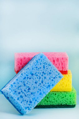 Mavi arka planda renkli süngerler. Temizlik kavramı.