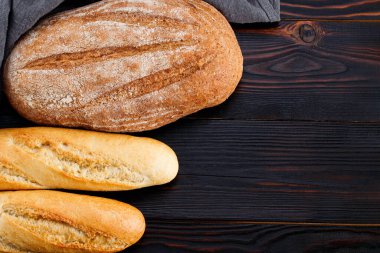 Ahşap masa arkasında ekmek ve baget. Üst görünüm.