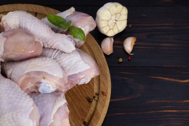 Çiğ tavuk bacağı, ahşap arka planda baharatlı tavuk budu. Üst görünümü kopyala.