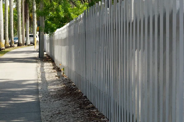Beyaz duvar çit kaldırım boyunca — Stok fotoğraf