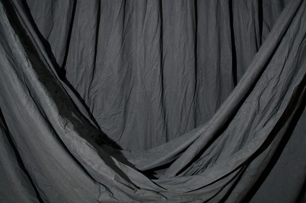 Drapated black backdrop cloth lit by blue green gel — Stok Foto