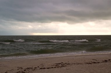 Yoğun fırtına bulutları, Bonita Springs, Florida 'daki Meksika körfezinde gökyüzünü dolduruyor..