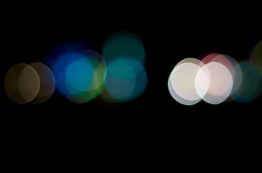 Bir sıra odak dışı renkli ışık gece gökyüzünü oluşturan bir açıyla yuvarlak şekil tasarımı oluşturur.