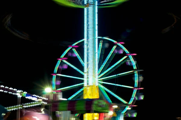 Towering Amusement Park Carnival Ride Blurred People Swings Machine Rotates — Stock Photo, Image