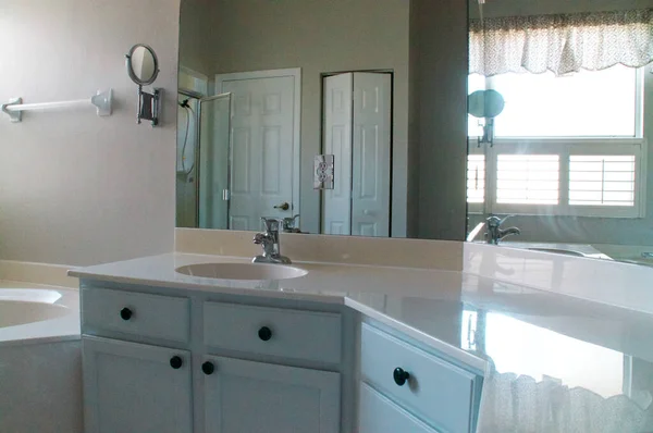 空浴室中的水池和镜像墙视图 图库图片