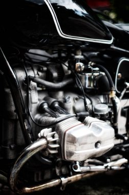 Eski alüminyum sersemletici tarzın sanatsal görüntüsü, siyah antika motorlu, sığ alan derinliği olan çift motora karşı..