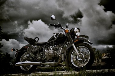 vintage motorcycle under storm clouds clipart