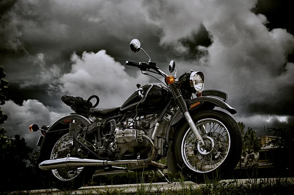 Motocicleta vintage bajo nubes de tormenta — Foto de Stock