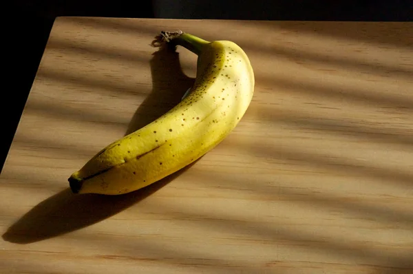 Rijpe banaan op teller in de zon — Stockfoto