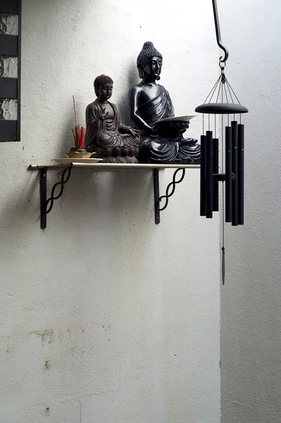 Dos buddhas en estante con incienso y campana de viento — Foto de Stock