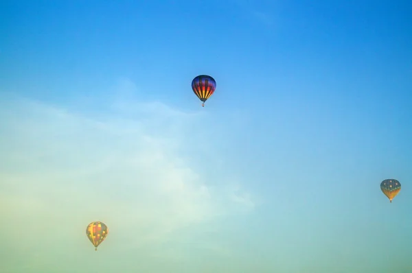 Three hot air balloons flying above morning fog — Stock Photo, Image