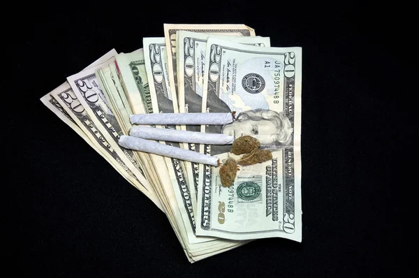 Fanned money with marijuana on black — Stock Photo, Image