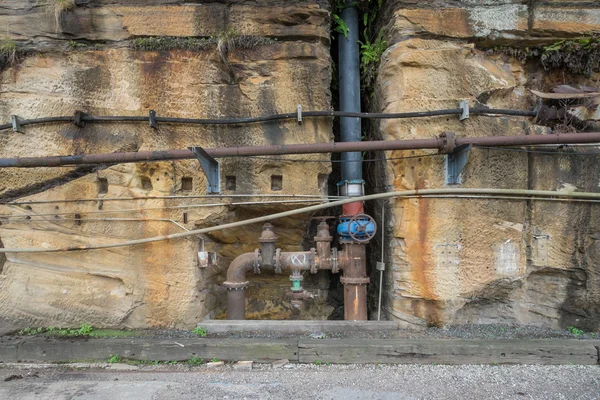Old rusty industrial pipes in a wall — Stock Photo, Image