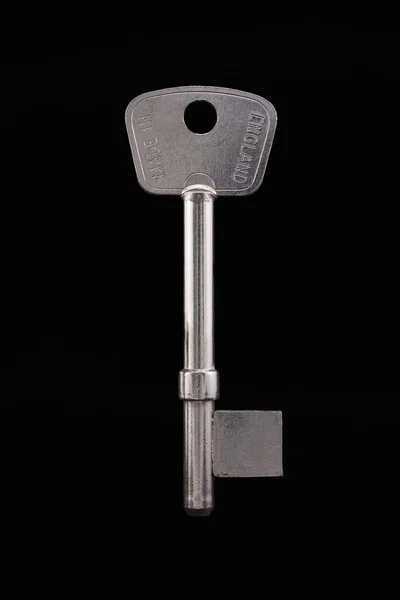 Llave en blanco aislada en negro — Foto de Stock