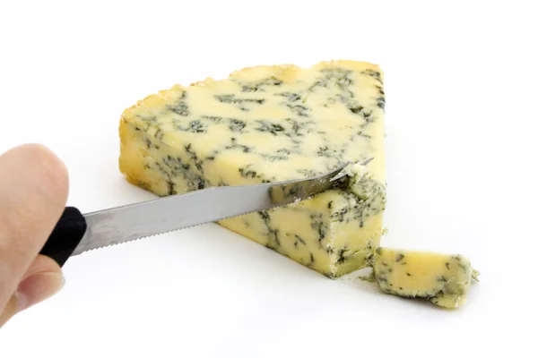 Wedge of blue cheese being cut over white — Stock Photo, Image