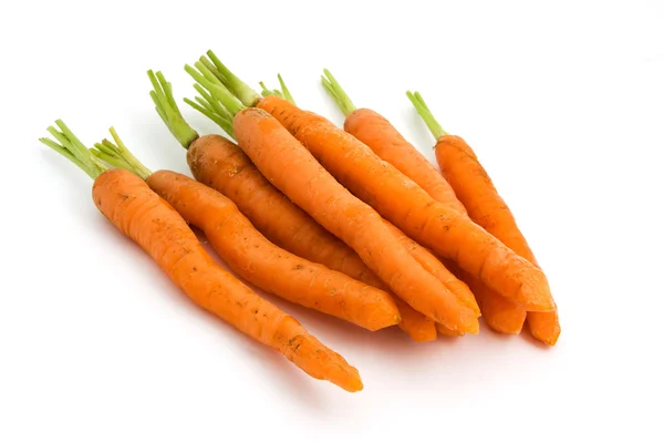 Pile of organic carrots with green tops over white — Stock Photo, Image