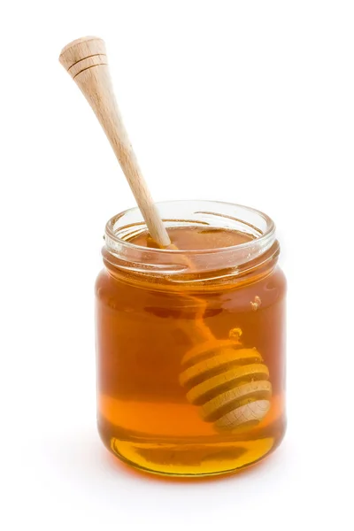 Honey drizzler in a jar of honey Stock Image