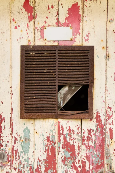 Rostiger Lüftungsschlitz in einem alten, abblätternden Türhintergrund — Stockfoto