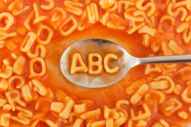 Abc harfleri bir kaşık üzerinde domates soslu makarna şeklinde 