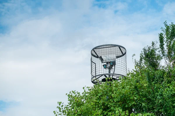 Une caméra de sécurité en cage derrière les buissons . — Photo