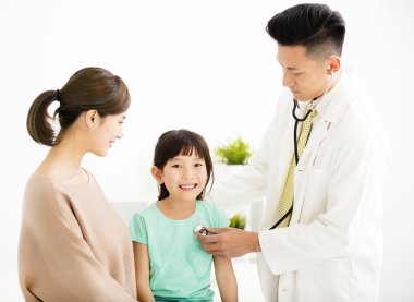 küçük bir kız ofiste inceleyerek genç tıp doktoru