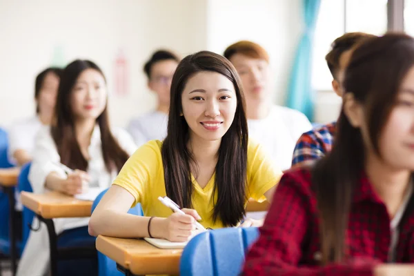 Lachende vrouw college student zitten met klasgenoten — Stockfoto