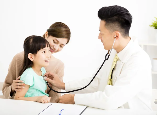 Young medical doctor examining a little girl in office — Stock Photo, Image