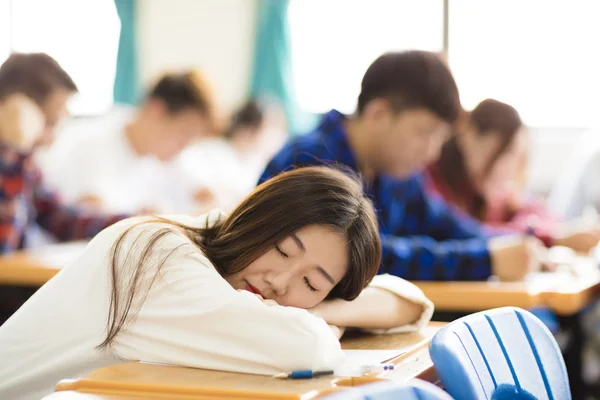 Unavený a spal vysokoškolský student pro zkoušky v učebně — Stock fotografie