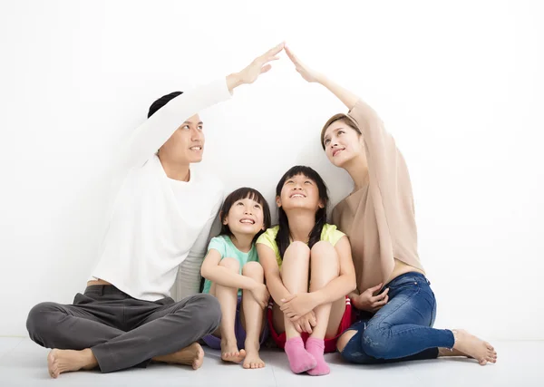 Lycklig familj sitter tillsammans och gör hemskylten — Stockfoto