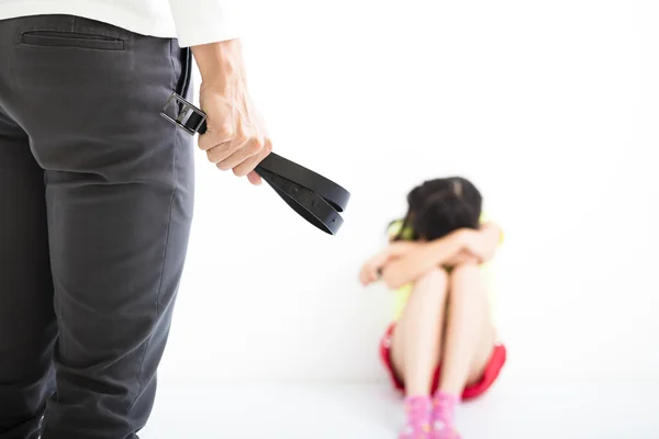 Angry man holding leather belt and terrified child sitting — Stock Photo, Image