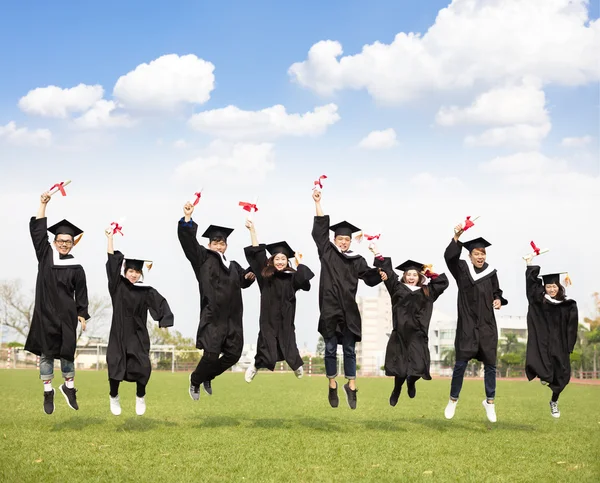 Happy young group graduation jumping together — Stock Photo, Image