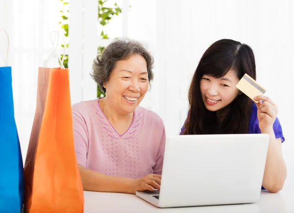 Щаслива старша мати і дочка з ноутбуком і кредитною карткою — стокове фото