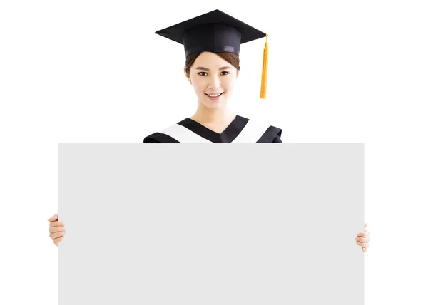 Feliz graduado feminino mostrando espaço cópia no quadro em branco — Fotografia de Stock