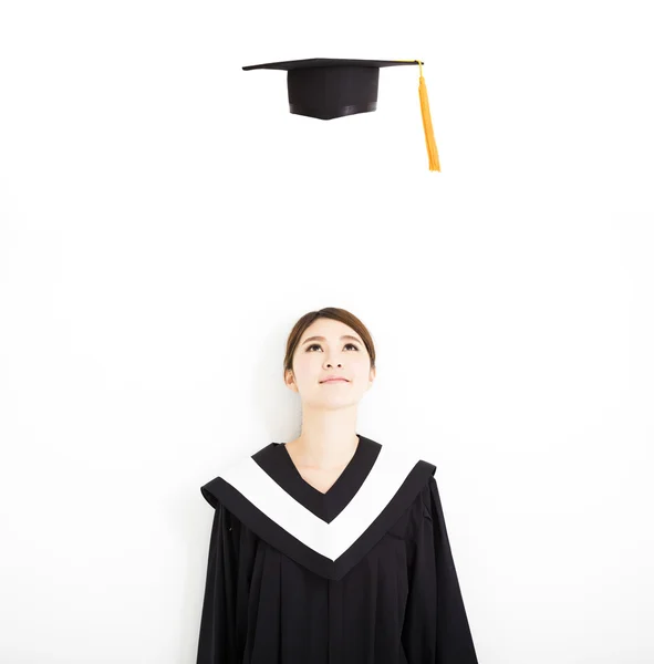 Feliz graduado feminino olhando o boné de formatura no ar — Fotografia de Stock