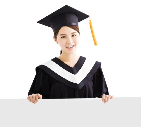 Feliz mujer graduada mostrando espacio de copia en el tablero en blanco — Foto de Stock