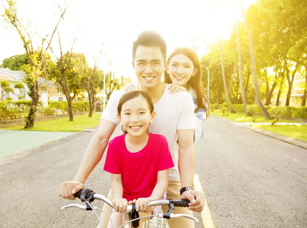 Ευτυχισμένη οικογένεια στην ασιατική τη διασκέδαση στο πάρκο με ποδήλατο — Φωτογραφία Αρχείου