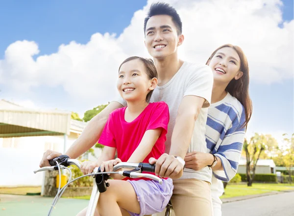 Счастливая азиатская семья веселится в парке с велосипедом — стоковое фото