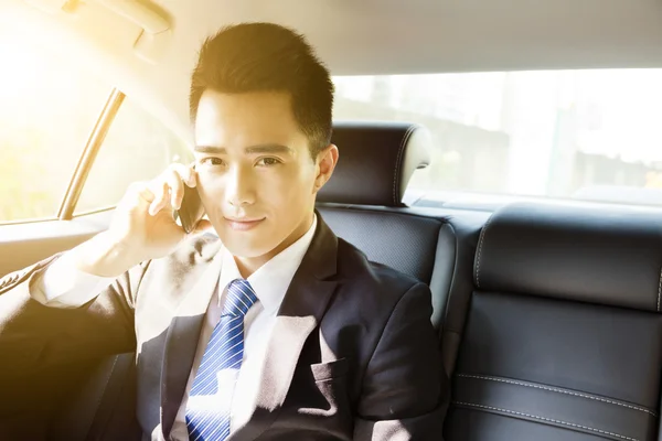 Mladý podnikatel mluví po telefonu v autě na ranní — Stock fotografie