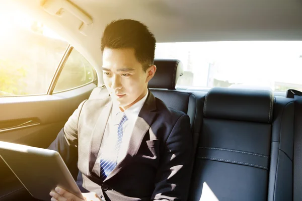 Jungunternehmer nutzt Tablet-PC morgens im Auto — Stockfoto