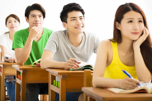 Jovem grupo de estudantes universitários sentado em uma sala de aula — Fotografia de Stock