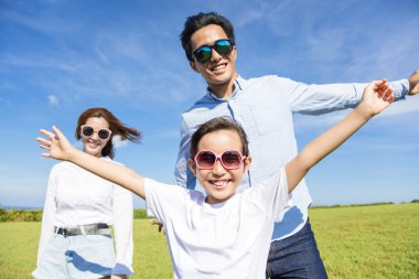 Çimenlerin üzerinde oynarken mutlu genç aile