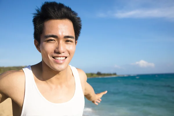 Χαλάρωση και χαμογελαστός νεαρός άνδρας στην παραλία — Φωτογραφία Αρχείου