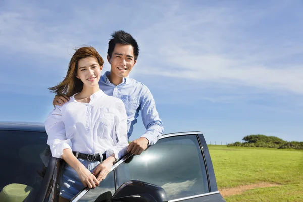 Pasangan muda berdiri di dekat mobil dan menikmati liburan musim panas — Stok Foto