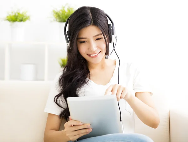 Young Woman with headphones and tablet in  living room — Stock Photo, Image