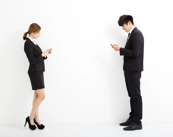 Joven hombre y mujer de negocios sosteniendo el teléfono inteligente — Foto de Stock