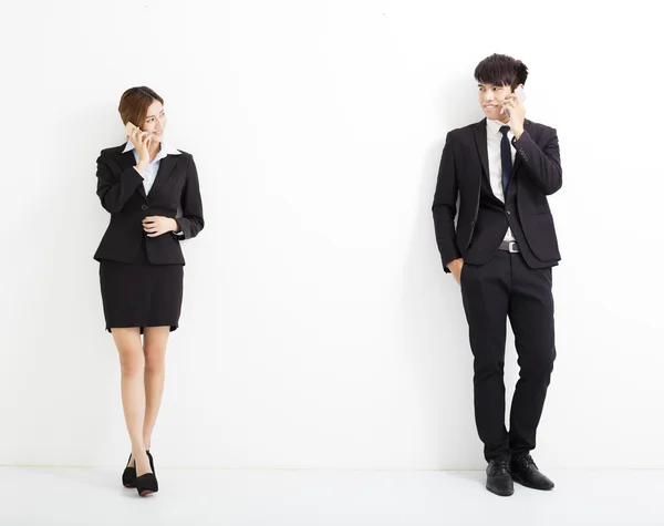 Jovem homem de negócios e mulher falando ao telefone — Fotografia de Stock