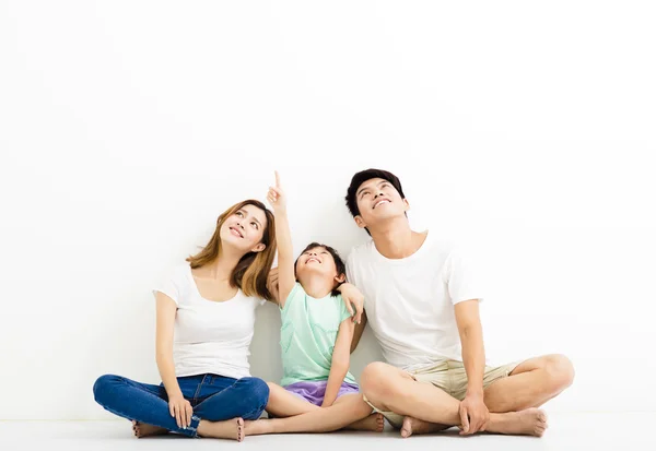 Familia joven y feliz señalando y mirando hacia arriba —  Fotos de Stock