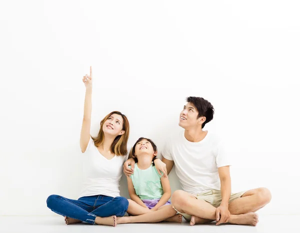 Glückliche junge Familie zeigt und schaut auf — Stockfoto