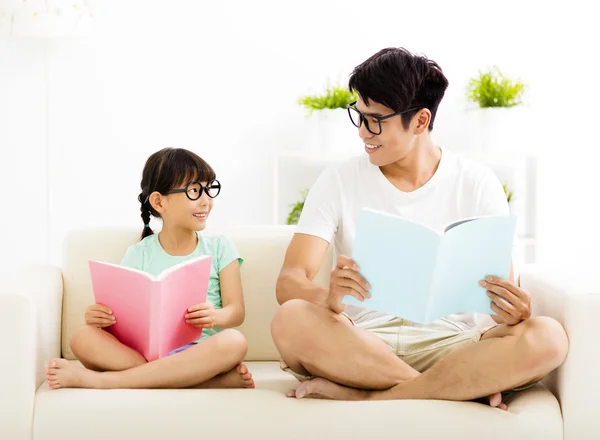 Père et fille étudient ensemble sur canapé — Photo